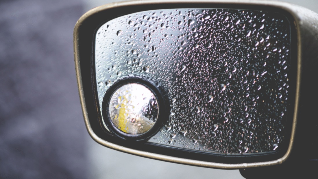 Raindrops on a car side mirror