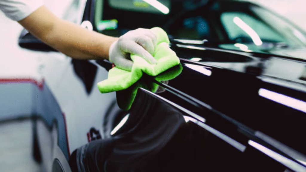 Person polishing a black car surface