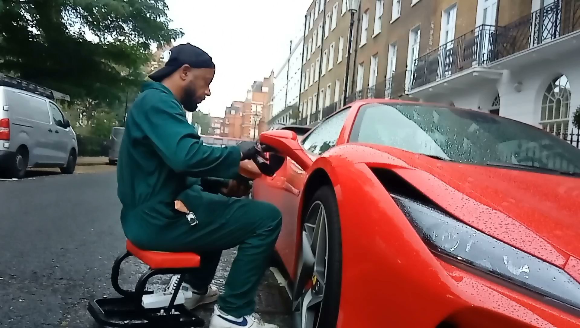 Person cleaning a red sports car.